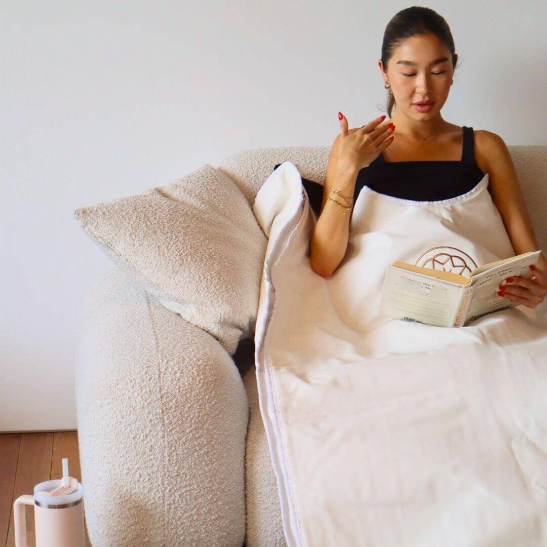 women relaxing on the sofa using the sauna blanket