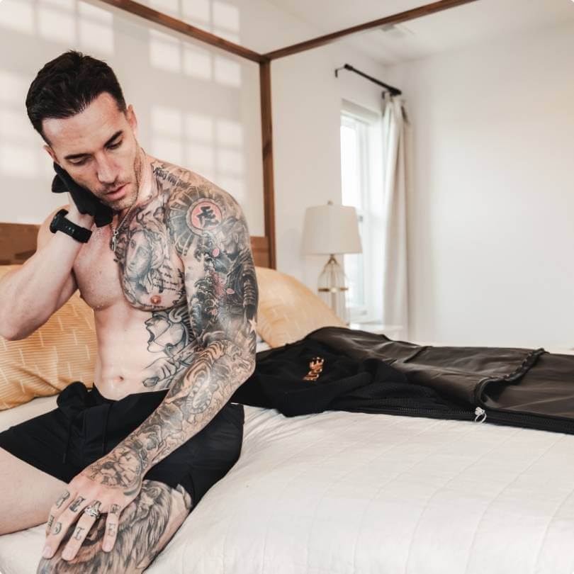 Man drying down the sauna blanket post-use, preparing for storage, as final step of wellness ritual.