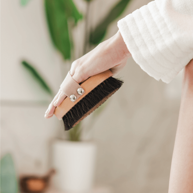 Ion-charged copper dry brush with natural bristles used on dry skin for exfoliation and lymphatic support